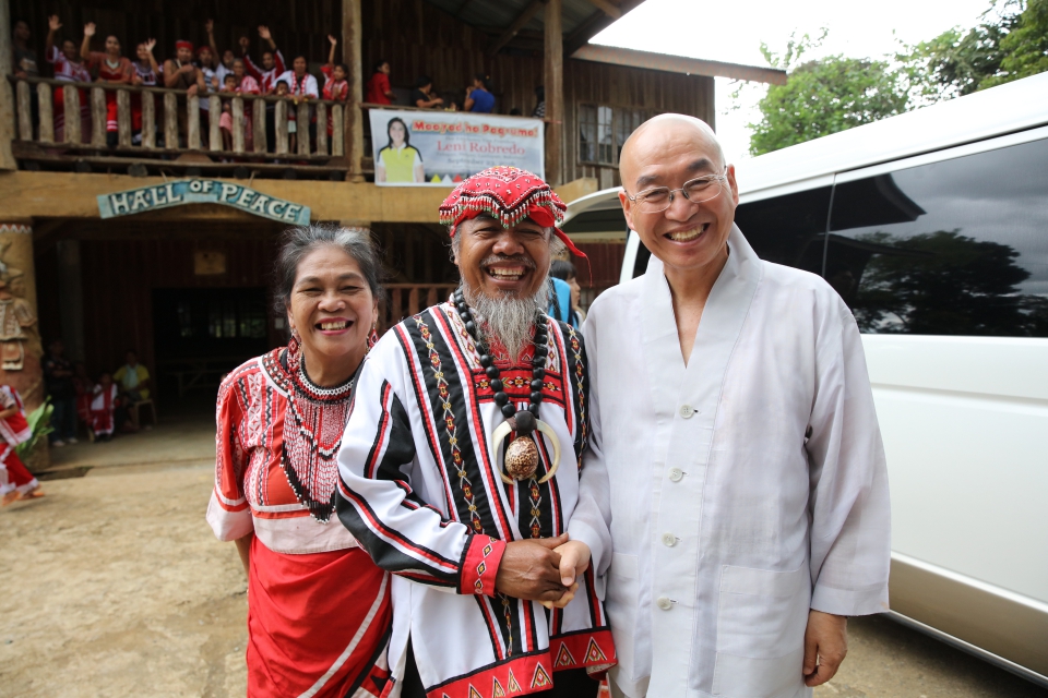 Sunim shakes hands with Vice Chieftain Datu with village people waving goodbye in the background