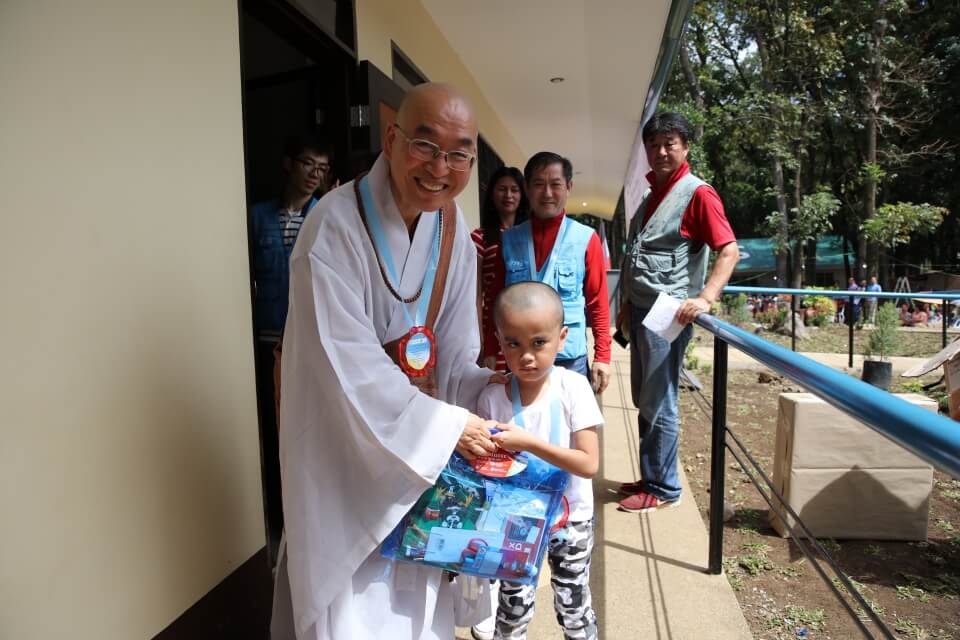 Sunim hands enrollment gift for one of the students